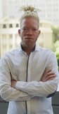 Vertical video of portrait of albino african american businessman. business in creative office and body inclusivity.