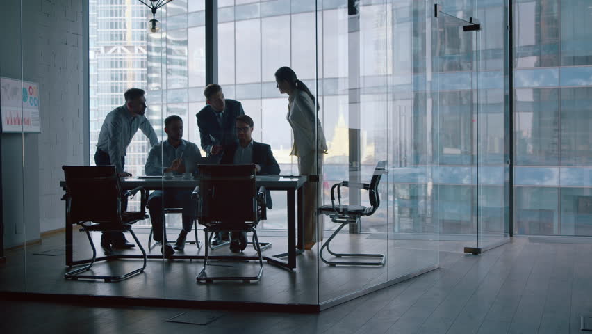 Corporate team discussion using computer technology while sitting at desk