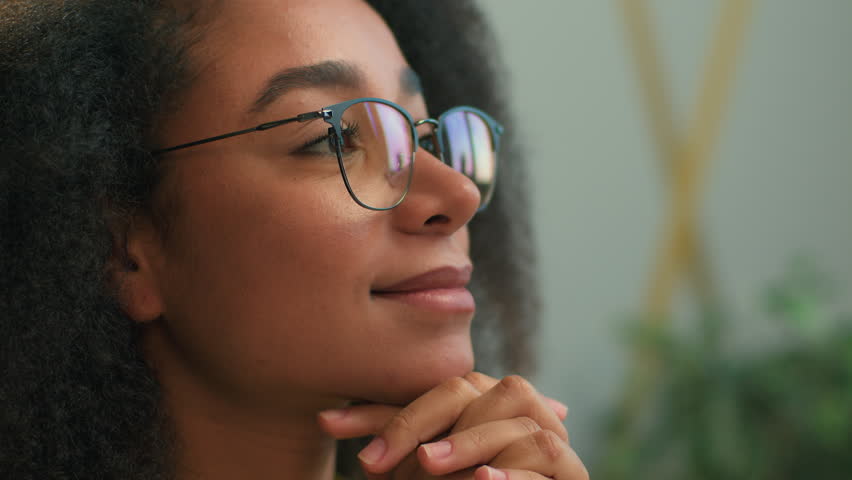Close up African American business woman in eyeglasses looking away thinking smiling thoughtful ethnic girl happy cheerful businesswoman in glasses think contemplate look dream dreaming at office talk Royalty-Free Stock Footage #3475541793