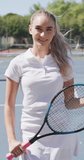 Vertical video of portrait of happy caucasian female tennis player with tennis racket. female tennis, sport and competition.
