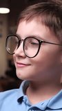 vertical video portrait of a Caucasian intelligent smart boy wearing glasses