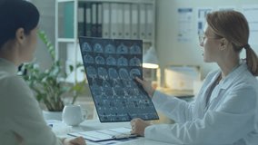 Female doctor explaining MRI scan to patient and commenting on results of medical examination during medical appointment in clinic - Powered by Shutterstock - Get 15% off with code: PIKWIZARD15