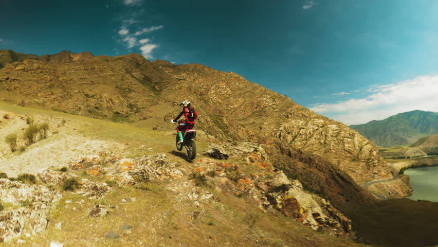 Sportsman deftly maneuvers motorcycle. Bike kicks up cloud of dust as testament to raw power and agility required in world of extreme motocross