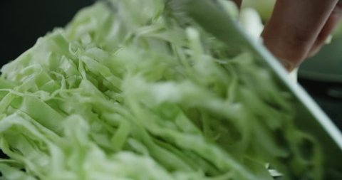 cabbage slicing in slow motion macro, the chef works in the kitchen