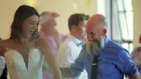 Father and bride dancing together on her wedding day with all of the other guests.