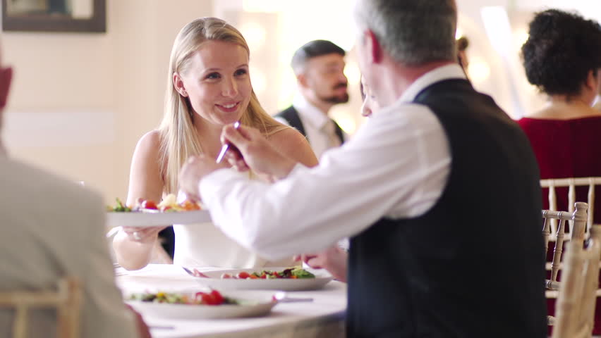 People are socialising at a wedding dinner party while passing plates and enjoying food.  Royalty-Free Stock Footage #34757818