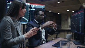 Two mixed-raced workers pointing at computer screen. Noticing mistake in system. Woman holding phone and comparing data with graphs. People in stressful moment. Loosing investment. - Powered by Shutterstock - Get 15% off with code: PIKWIZARD15