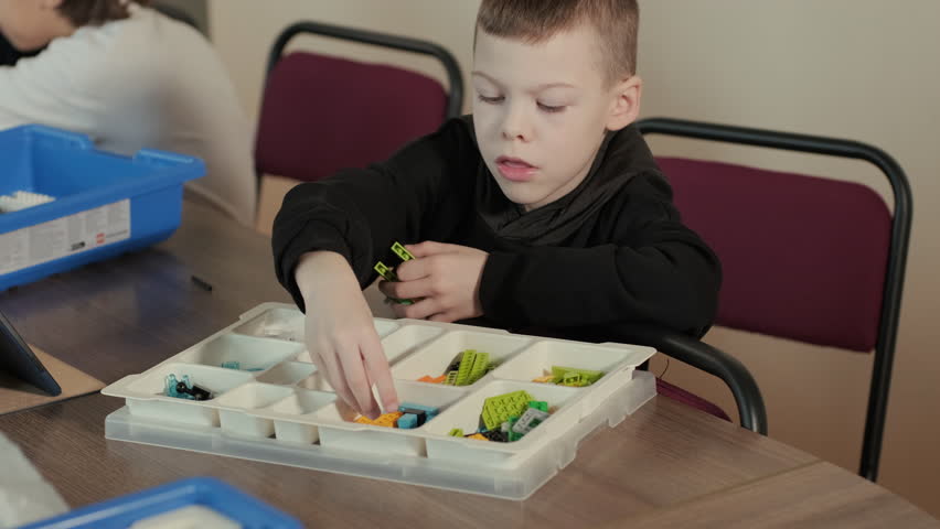 Children engage in STEM learning activities, assembling robotics kits with focus and teamwork in a classroom setting