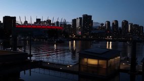 Science World Olympic Village and Rogers Arena at night in Vancouver, with city lights and water reflections. British Columbia, Canada. 4k video
