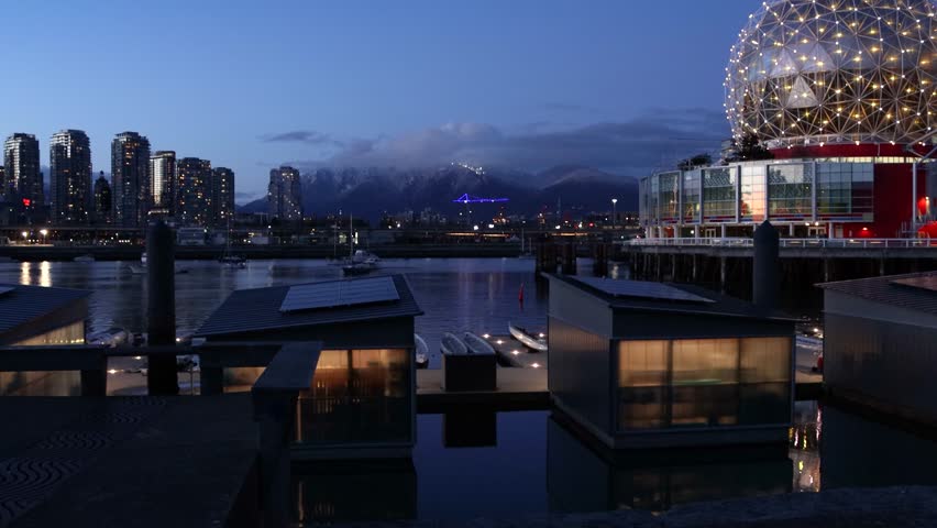 Science World Olympic Village and Rogers Arena at night in Vancouver, with city lights and water reflections. British Columbia, Canada. 4k video