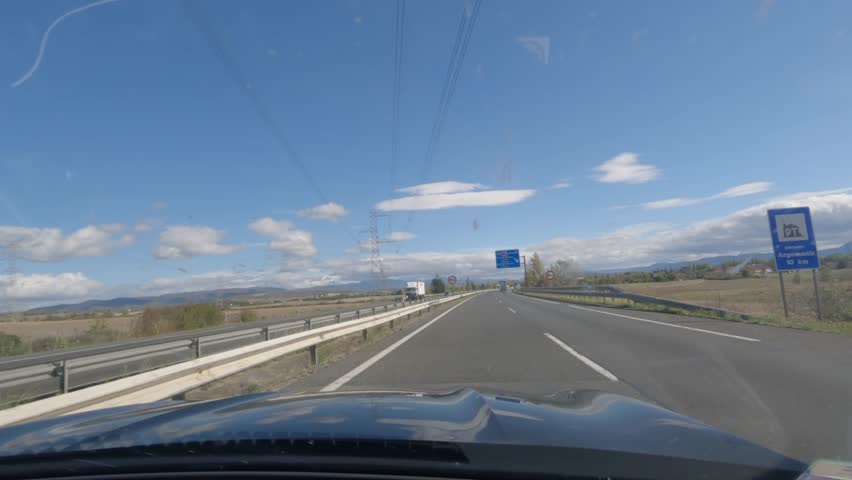 First person view, FPV, from dashcam of car driving in the city of Vitoria-Gasteiz in the Basque region, Northern Spain. Road trip video in POV, with bright sunny skies