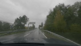 First person view, FPV, from dashcam of car driving in the Pyrenees mountains on the border of Spain, France, Andorra in a storm. Road trip video in POV from inside vehicle, with rain and dark skies