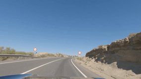 First person view, FPV, from dashcam of car driving on highway towards Valencia in Tabernas desert, Almeria, Andalusia, Spain, Europe. Road trip video in POV in arid, dry climate