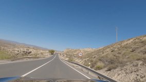 First person view, FPV, from dashcam of car driving on highway towards Valencia in Tabernas desert, Almeria, Andalusia, Spain, Europe. Road trip video in POV in arid, dry climate
