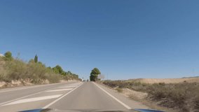 First person view, FPV, from dashcam of car driving on highway towards Valencia from Tabernas desert, Almeria, Andalusia, Spain, Europe. Road trip video in POV on beautiful tree-lined road with farms