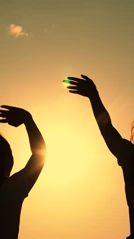 Celebrate summer day at beach party. Friends have fun at beach party during sunset. Free girls dance merrily on summer evening, sun. Group of young people having fun dancing with raised hands to music