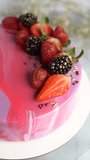 Beautiful cake with mirror glaze and fresh berries. Vertical video.