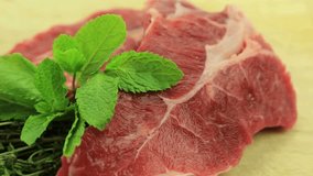 Culinary Delight: Slow Pan of Raw Steak with Green Leaves in 4K Video
