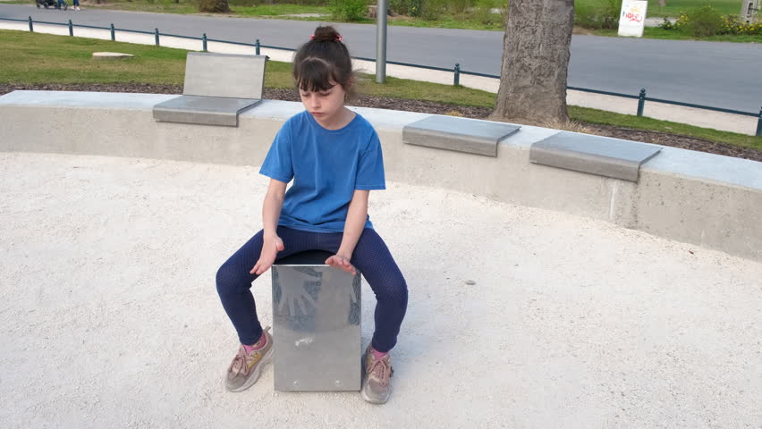 Child playing rhythm in day time. A view of little girl play rhythm in the park.