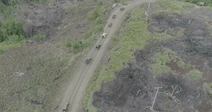 Drone video of a double axle car passing the Trans Papua road which is full of obstacles