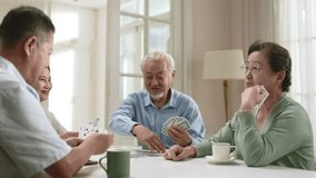two happy senior asian couples gathering at home playing cards together - Powered by Shutterstock - Get 15% off with code: PIKWIZARD15