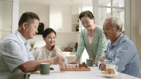 two senior asian men playing chess at home with wives watching by the side - Powered by Shutterstock - Get 15% off with code: PIKWIZARD15