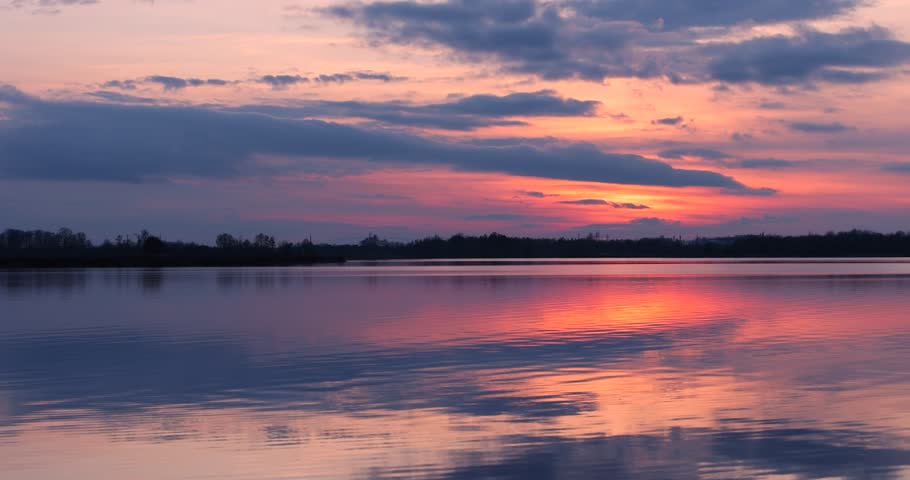 reflection of the sky in the lake during sunset, winter sunset on the lake after the ice melts