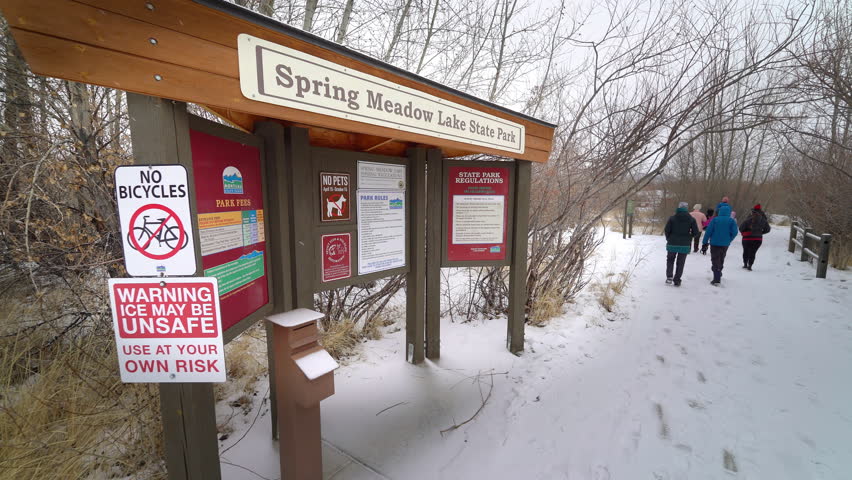 Group walking through snow away from signs
