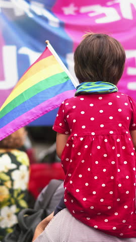 Little kid sit mother shoulder. Gay protest against no homophobia. Family walk lgbt pride parade. Child watch lesbian strike. Bi parent show us csd fest daughter. Peaceful rally Girl hold rainbow flag Royalty-Free Stock Footage #3476263623