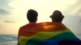 Romantic moment of bisexual gay male couple walking on the beach with their arms crossed with rainbow flag. LGBTQ man couple have a romantic moment on the beach. LGBT and homosexual concept. - Powered by Shutterstock - Get 15% off with code: PIKWIZARD15