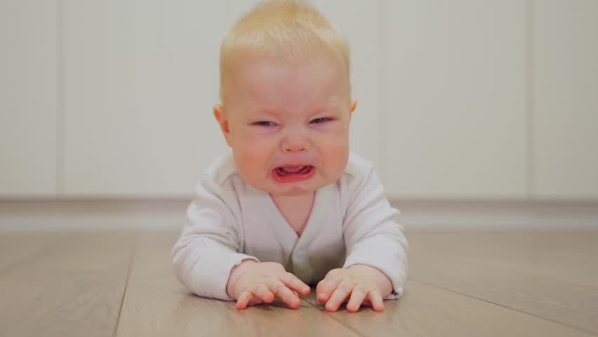 White Caucasian baby boy is nervous and crying due to colic or teething. Emotions of a child with abdominal pain, toothache. Dissatisfied, crying, upset, sad Newborn. Parenting issues. Royalty-Free Stock Footage #3476293657