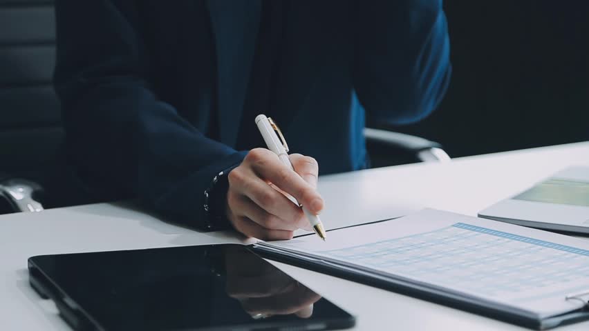 Young confident successful businesswoman using laptop and digital tablet, focused on work, creating business strategy plans on tablet. Female business professional distantly working online from home.