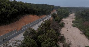 An aerial drone captured sight of the Delhi-Dehradun Expressway, a 4-lane highway currently under construction, swiftly slicing through a dense jungle in Uttarakhand, India. 4k
