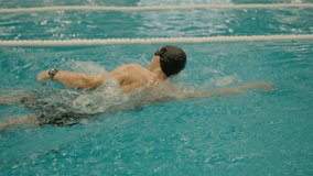 Athletic man swim freestyle in swimming pool. Professional male swimmer training in swimming pool. Active lifestyle and sport concept - Powered by Shutterstock - Get 15% off with code: PIKWIZARD15