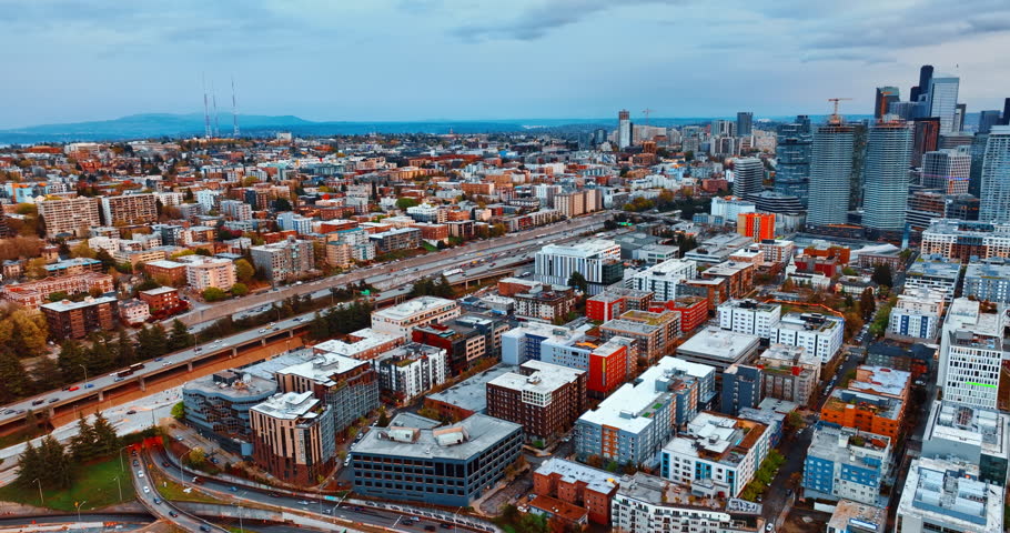 Busy highways along the low-rise architecture in the scenery of Seattle, Washington, United States. Drone footage above the city after sunset.