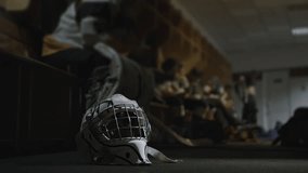 Helmet mask of Ice hockey goalkeeper goaltender is on floor inside locker room. Protective equipment gear in checkroom. Players sitting resting during break between periods intermission. Dressing room - Powered by Shutterstock - Get 15% off with code: PIKWIZARD15