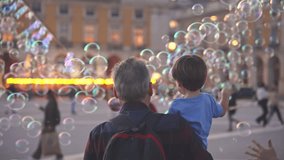 Happy childhood. Fun boy enjoy soap bubbles performance. Colorful fly show. Joyful child catch lot foam circles. Public place performer. Urban holiday square. Kid play city street. Entertainment event - Powered by Shutterstock - Get 15% off with code: PIKWIZARD15