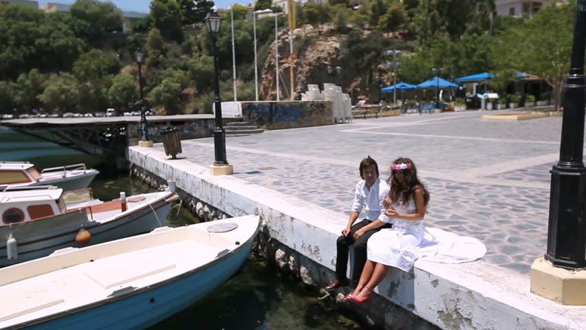 Happy newlyweds sitting at the pier