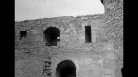 Ancient walls of defensive fort, bastion, view inside. Family trip to historical places. Tourists walk through castle courtyard. Archival historic black white film. Old retro archives. 1980s Crimea