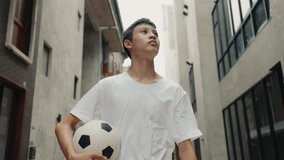 Asian Young Football Player Returns to His Home, Sweaty After Training, and Takes a Look at Everything. Tired Serious Guy Walks Home from a Football Match and Dreaming. Sport and People Concept - Powered by Shutterstock - Get 15% off with code: PIKWIZARD15