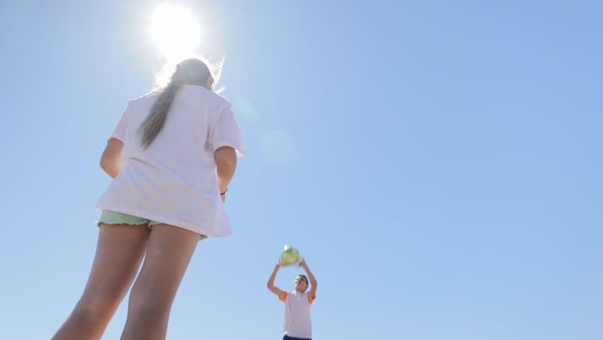 Happy brother and sisterhaving fun playing volleyball on beach. Children playing football tropical beach . Cute children running with ball. Summer holidays seashore. Family holiday with children