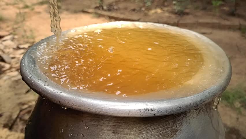 Bad, dirty, contaminated, impure, unhealthy, unhygienic, muddy and rusty brown colour drinking tap water overflowing from pot. Water shortage, scarcity crisis in india and africa rural village concept