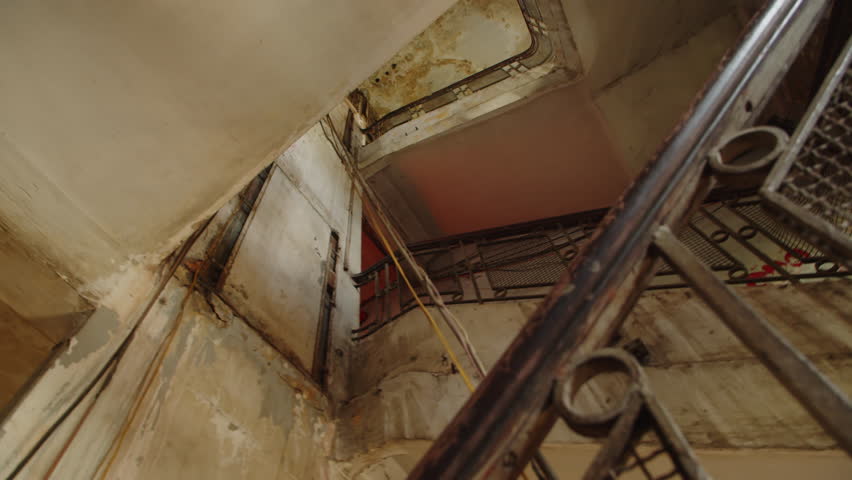 Low angle of old staircase in abandoned building with shabby walls, no people
