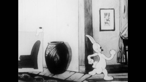 1930s: Animation of rabbit in hallway, closes door, dog tries to open it, rabbit appears from door's drawer, slaps and tickles dog. Dog with hiccups, balloons appear, dog shuts mouth, body stretches.