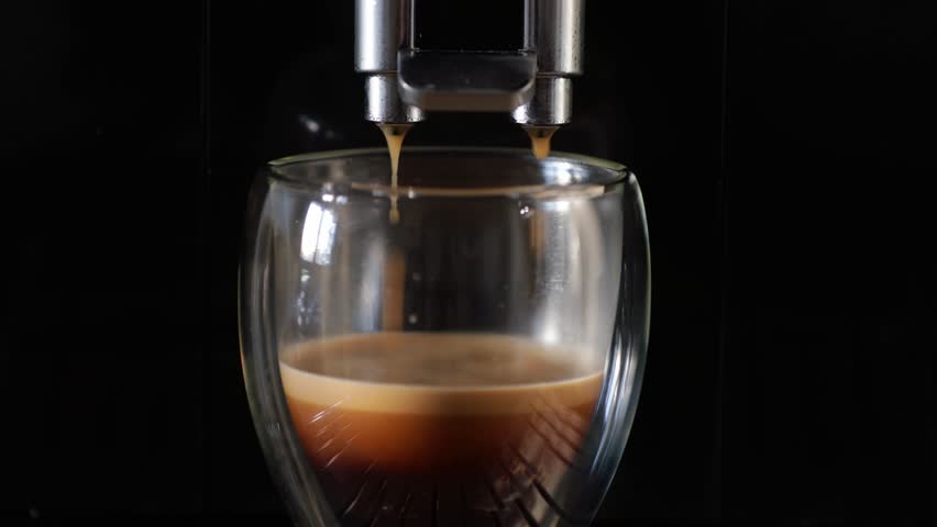 Making coffee in coffee machine. Morning routine - getting fresh coffee in glass cup. Close up video