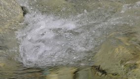Beautiful water in a mountain river in slow motion video. Shooting speed 60fps, slow motion. Live shooting of the most beautiful nature river mountain water. The camera is not static.