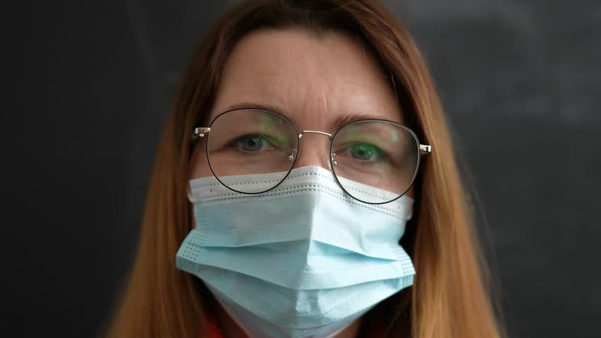 Happy family concept.close up of girls face in medical mask.woman looks at camera.face mask protects against virus.girl at home wearing medical mask.protection of respiratory tract from infection Royalty-Free Stock Footage #3476823417