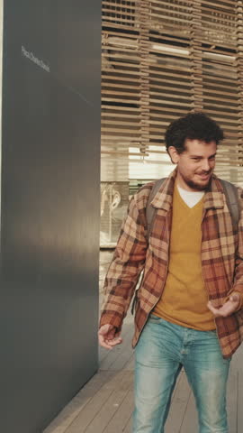 VERTICAL VIDEO, Students walk down the street. Guys students having fun talking walk down the street