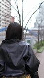 Vertical video of a young Japanese woman in her 20s walking around Gotanda Station, Shinagawa-ku, Tokyo in winter