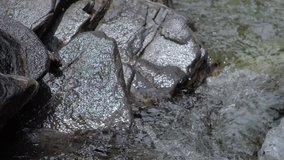 Beautiful water in a mountain river in slow motion video. Shooting speed 180fps, slow motion. Live shooting of the most beautiful nature river mountain water. The camera is not static.